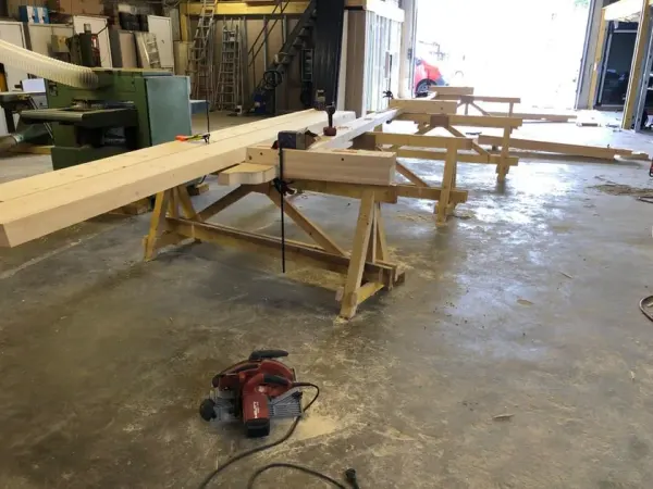 Poutre en cours de taille sur tréteaux dans l'atelier