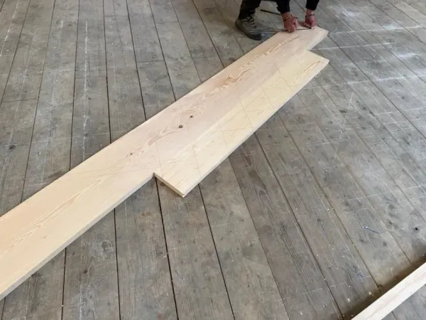 Tracé d'épure à la main sur une pièce de charpente