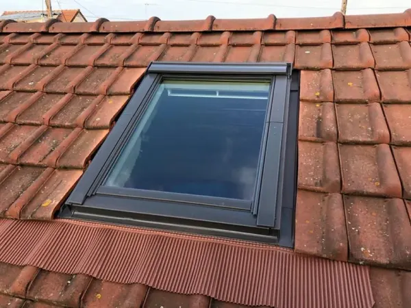 Fenêtre de toit intégrée à une couverture en tuiles vieillies, à Le Mesnil-le-Roi