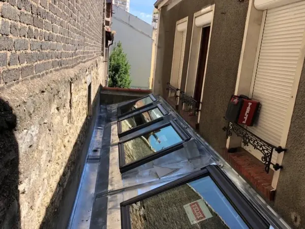 Verrière et couverture zinc posées en fond de cour parisienne, à Paris