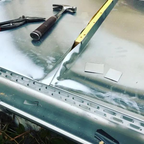 Façonnage du zinc à l'outil sur une gouttière parisienne, à Paris