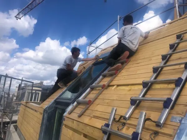 Pose d'un châssis vitré sur un voligeage neuf, en hauteur, à Paris