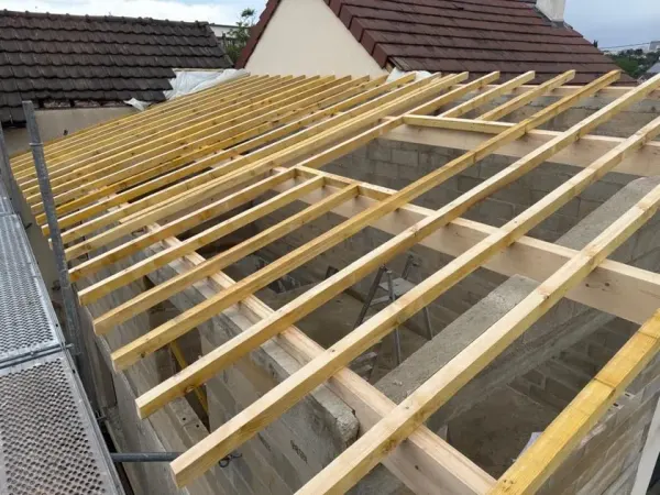 Charpente neuve posée sur une extension en parpaing, chevrons en place, à Vitry-sur-Seine